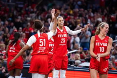 Former Indiana Fever player DeWanna Bonner (25) celebrates with Sydney Colson (51) and Lexie Hull (10).