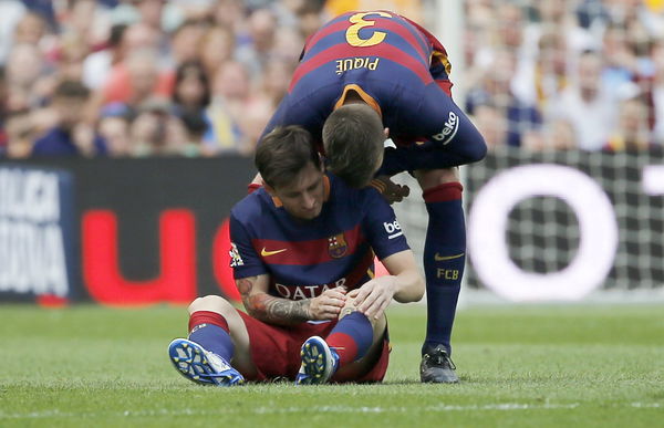 Barcelona&#8217;s Messi is comforted by his team mate Pique as he sits on the pitch after being injured during their Spanish first division soccer match against Las Palmas at Camp Nou stadium in Barcelona