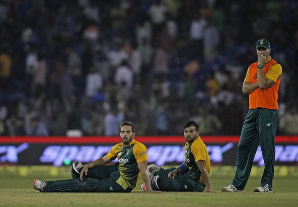 South African batsmen Farhaan Behardien and Jean-Paul Duminy sit on the field after the match was disrupted due to water bottles thrown by spectators during the second Twenty20 cricket match against India in Cuttack