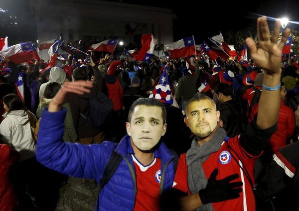 Chilean fans gather on the street with the image players of Alexis Sanchez and Arturo Vidal  in Concepcion after Chile&#8217;s victory over Peru in their Copa America 2015 semi-finals soccer match in Santiago