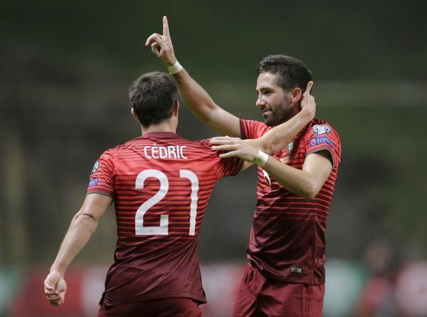 Portugal&#8217;s Moutinho celebrates his goal against Denmark with his teammate Cedric during their Euro 2016 qualifying soccer match at Municipal Stadium in Braga