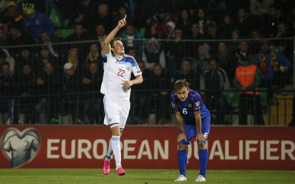 Russia&#8217;s Dzyuba celebrates his goal as Moldova&#8217;s Jardan reacts during their Euro 2016 group G qualifying soccer match against Moldova at Zimbru stadium in Chisinau