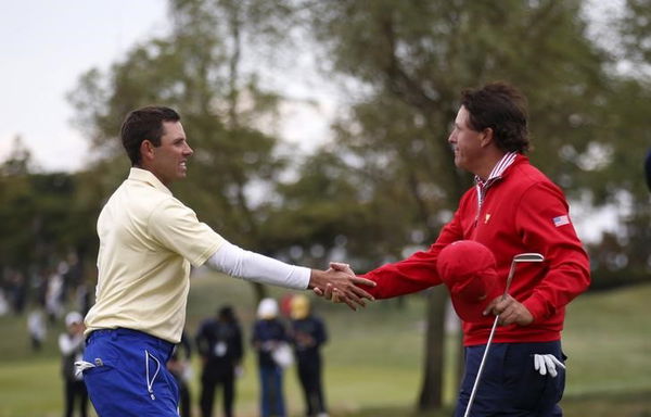 U.S team member Phil Mickelson shakes hands with international team member Charl Schwartzel of South Africa on the 14th hole during their singles matches of the 2015 Presidents Cup golf tournament in Incheon