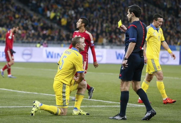 Ukraine&#8217;s Kucher receives a yellow card from referee Mazic during the Euro 2016 group C qualifying soccer match against Spain at the Olympic stadium in Kiev