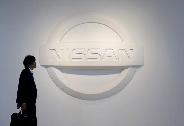 A man walks past the logo of Nissan Motor Co. at the company&#8217;s showroom in Yokohama