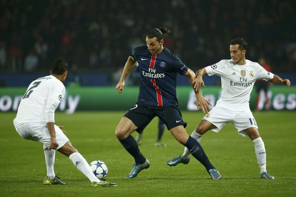 Paris Saint Germain&#8217;s Zlatan Ibrahimovic challenges Real Madrid&#8217;s Raphael Varane and Lucas Vazquez during their Champions League Group A soccer match at the Parc des Princes stadium in Paris