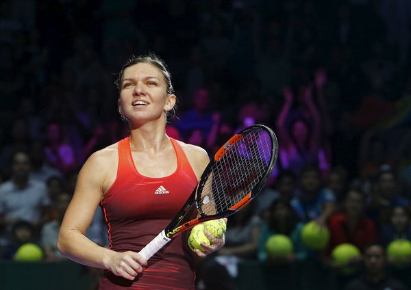 Simona Halep of Romania prepares to hit balls to fans after defeating Flavia Pennetta of Italy in their women&#8217;s singles tennis match of the WTA Finals at the Singapore
