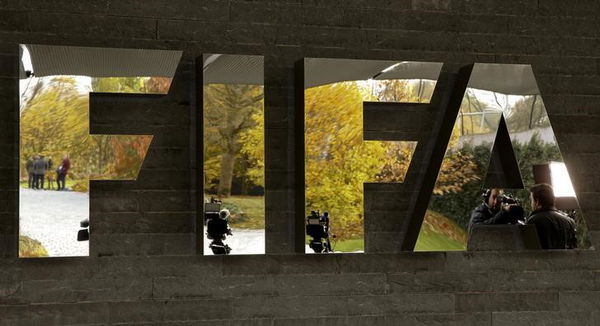 Journalists are reflected in FIFA&#8217;s logo as they wait during an extraordinary meeting of the FIFA Executive Committee in front of FIFA&#8217;s headquarters in Zurich