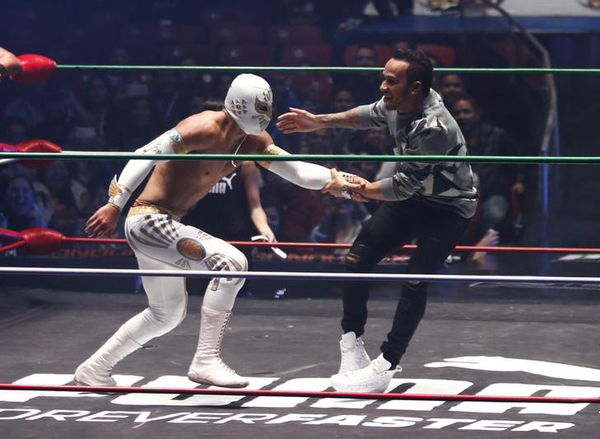 Mercedes Formula One driver Lewis Hamilton of Britain performs with Mexican wrestlers at the Coliseo Arena during a promotional event in Mexico City