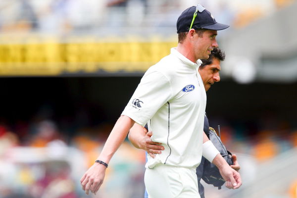 New Zealand bowler Tim Southee leaves the field injured with the team physio during the first cricket test match between Australia and New Zealand in Brisbane