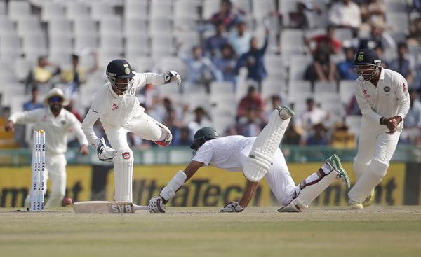 India&#8217;s wicketkeeper Saha stumps South Africa&#8217;s captain Amla as India&#8217;s Pujara watches during the second day of their first cricket test match, in Mohali