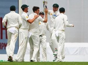 Australian bowler Mitchell Marsh celebrates the wicket of New Zealand captain Brendon McCullum, during the first cricket test match between Australia and New Zealand in Brisbane