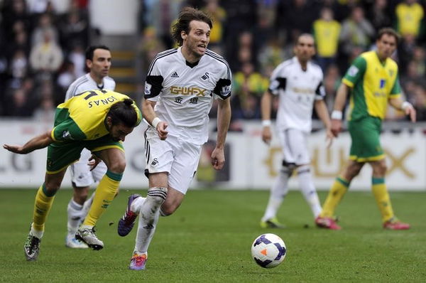 Norwich City&#8217;s Jonas Gutierrez fails to stop Swansea City&#8217;s Michu during their English Premier League soccer match in Swansea