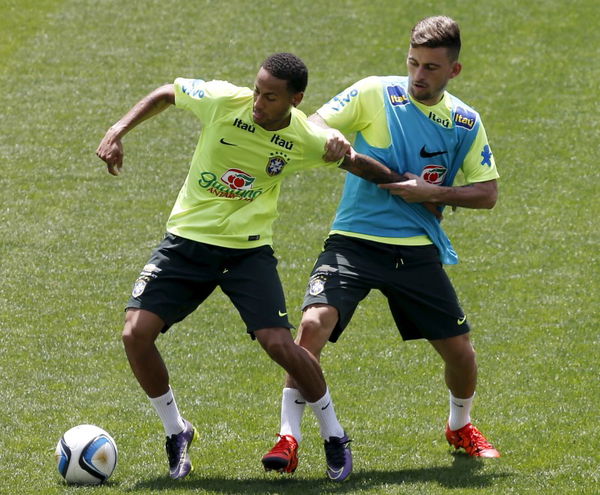 Brazilian soccer player Neymar and Lucas Lima fight for the ball during their training session at Arena Corinthians stadium in Sao Paulo