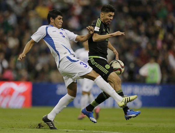 Oribe Peralta of Mexico battles for the ball against Roberto Dominguez of El Salvador during their 2018 World Cup qualifying soccer match