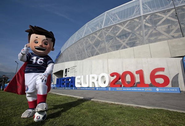 The official Mascot, Super Victor, for the upcoming Euro 2016 soccer championship, poses in front of the UEFA Euro 2016 logo at the Allianz Riviera stadium in Nice