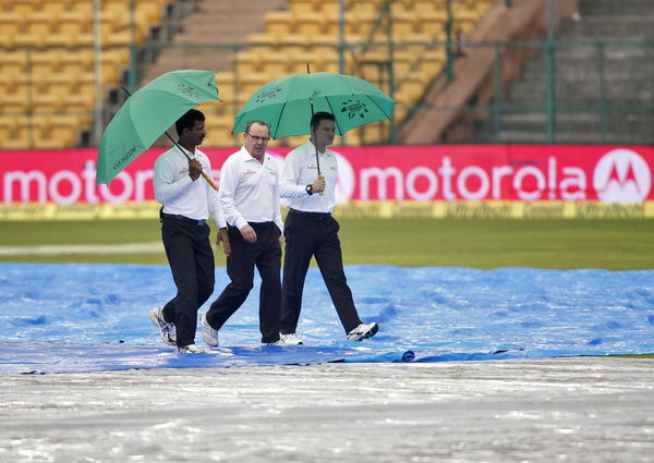 Umpires Nandan, Gould and Kettleborough walk as they inspect the field on the fourth day of the second test cricket match between India and South Africa in Bengaluru