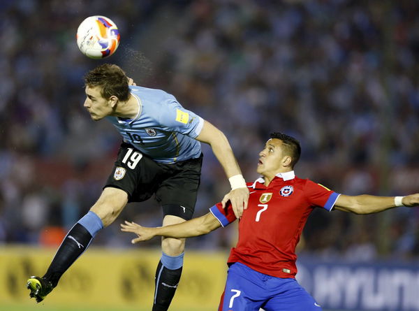 Uruguay&#8217;s Sebastian Coates heads the ball next to Chile&#8217;s Alexis Sanchez during their 2018 World Cup qualifying soccer match at Centenario stadium in Montevideo