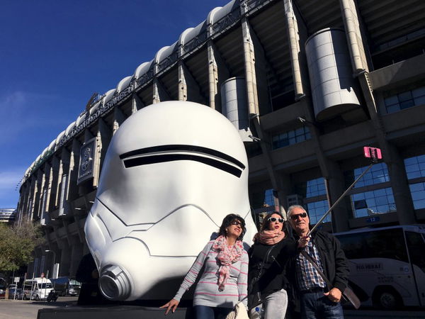 Local tourists take a selfie with a Storm Trooper mask outside Santiago Bernabeu Stadium in Madrid