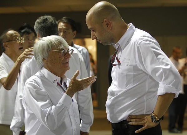 Formula One commercial supremo Ecclestone talks to Lopez after the third practice session of the Singapore F1 Grand Prix at the Marina Bay street circuit in Singapore