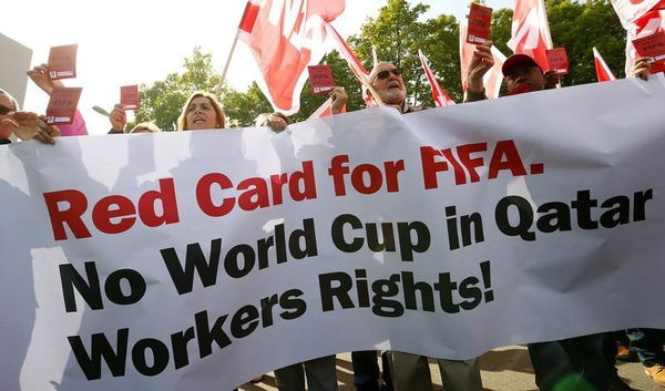 Members of the Swiss UNIA workers union display red cards and shout slogans during a protest in front of the headquarters of soccer&#8217;s international governing body FIFA in Zurich