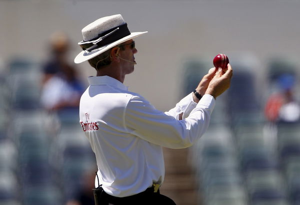 Umpire Nigel Llong inspects the ball during the fourth day of the second cricket test match between Australia and New Zealand at the WACA ground in Perth, Western Australia