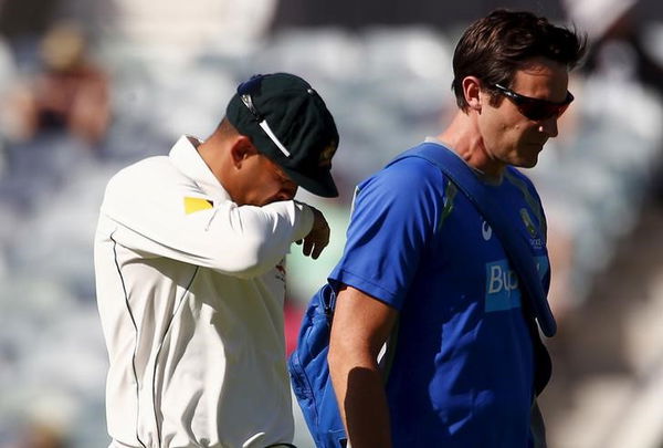 Australia&#8217;s Usman Khawaja reacts as he walks off the ground with a team trainer after suffering an injury during the second day of the second cricket test match against New Zealand at the WACA ground in Perth, Western Australia