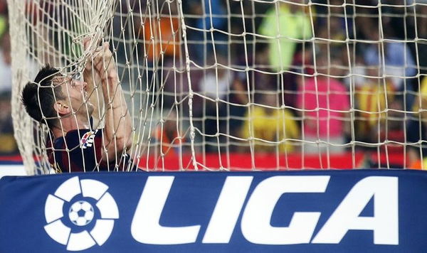 Barcelona&#8217;s Messi reacts while hanging from the net after missing a goal against Eibar during their Spanish first division soccer match at Camp Nou stadium in Barcelona