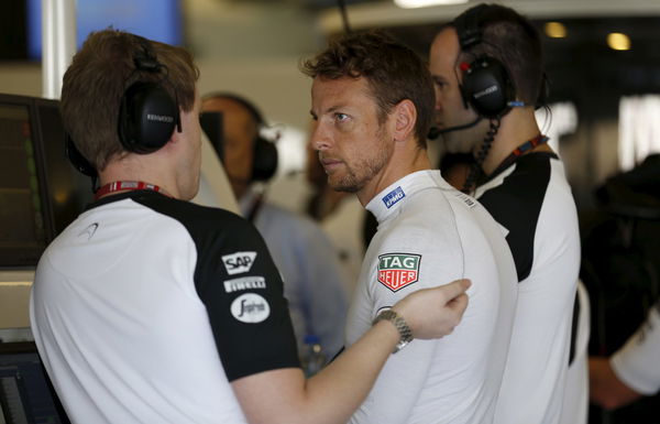 McLaren Formula One driver Jenson Button of Britain speaks to a crew member as he prepares for the third free practice session of Abu Dhabi F1 Grand Prix at the Yas Marina circuit in Abu Dhabi