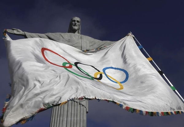 The Olympic Flag flies in front of &#8220;Christ the Redeemer&#8221; statue during a blessing ceremony in Rio de Janeiro