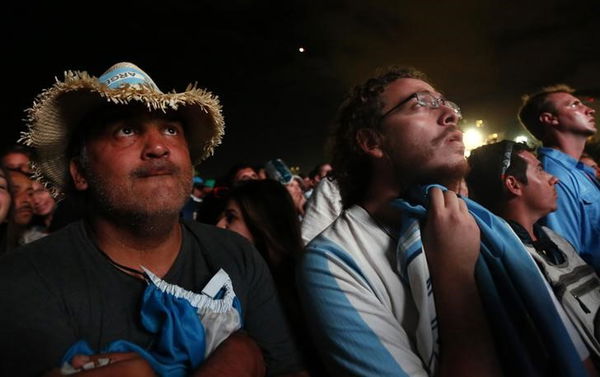 Fans of Argentina react on Copacabana beach as they watch the 2014 World Cup final match between Argentina and Germany in Rio de Janeiro