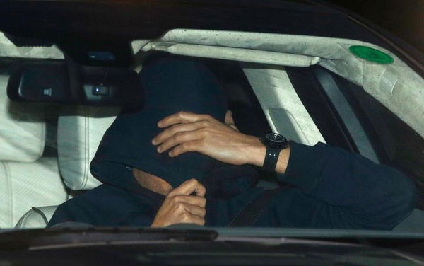 A man believed to be Jose Mourinho covers his face under a hoody as he is is driven out of Chelsea&#8217;s training, in Cobham southern England