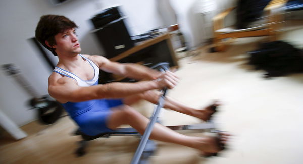 Francesco Tomba trains at a rowing machine in his room in Berlin