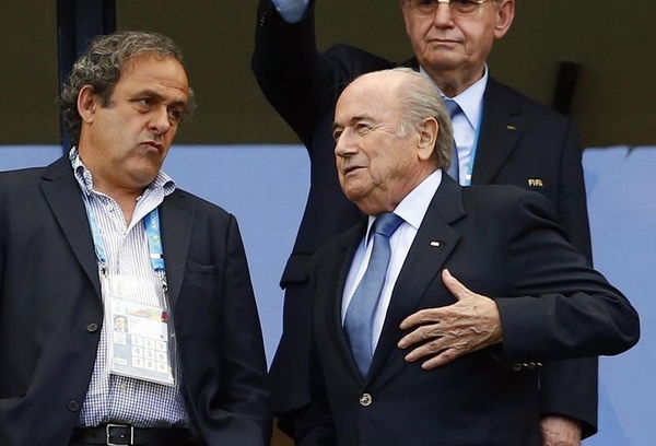 FIFA President Blatter speaks with UEFA President Platini before the 2014 World Cup Group G soccer match between Germany and Portugal at the Fonte Nova arena in Salvador