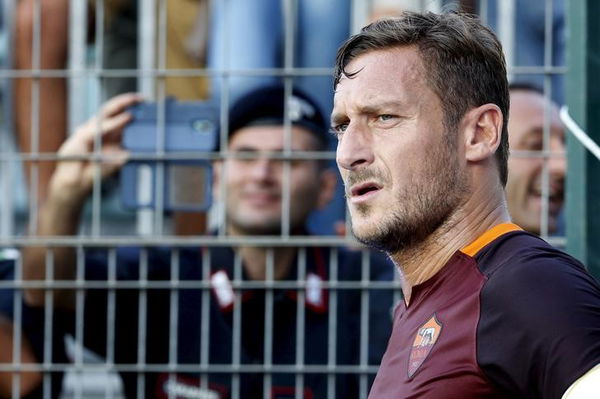 AS Roma&#8217;s Totti prepares to kick a corner as a Carabiniere takes a picture during the Serie A soccer match against Frosinone in Frosisone