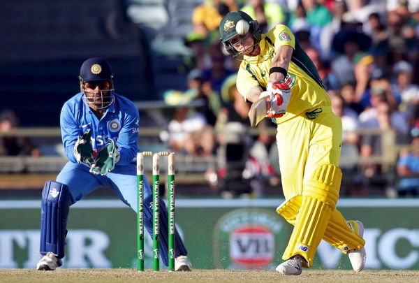 Australia&#8217;s Steve Smith hits a six as India&#8217;s wicketkeeper MS Dhoni looks on during the One Day International cricket match in Perth