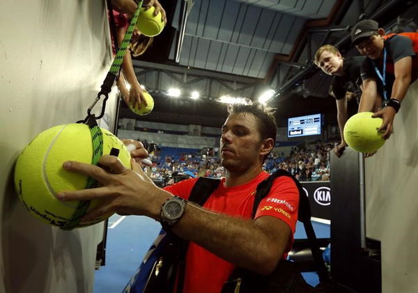 Switzerland&#8217;s Wawrinka signs autographs as he leaves after Russia&#8217;s Tursunov retired from their first round match due to an injury at the Australian Open tennis tournament at Melbourne Park, Australia