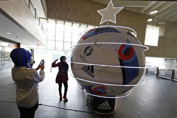 Youths take pictures near a decorated giant UEFA Euro 2016 soccer ball, dubbed &#8220;Beau Jeu&#8221;, in downtown Beirut