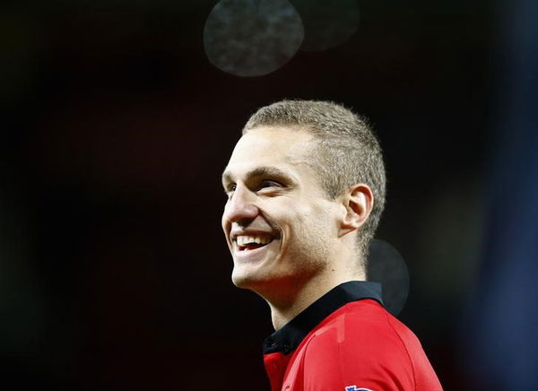 Manchester United&#8217;s Vidic, who has played his final home match for team, smiles following their English Premier League soccer match against Hull City at Old Trafford in Manchester