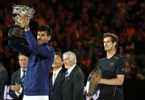 Serbia&#8217;s Djokovic holds up the men&#8217;s singles trophy in front of Britain&#8217;s Murray after winning their final match at the Australian Open tennis tournament at Melbourne Park