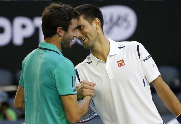 Serbia&#8217;s Djokovic and France&#8217;s Simon laugh as they shake hands at the net after Djokovic won their fourth round match at the Australian Open tennis tournament at Melbourne Park