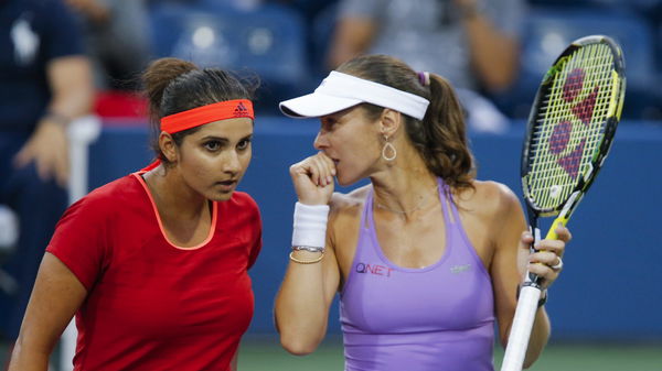 Mirza of India confers with playing partner Hingis of Switzerland during their women&#8217;s doubles semifinals match against Errani and Pennetta, both of Italy, at the U.S. Open Championships tennis tournament in New York