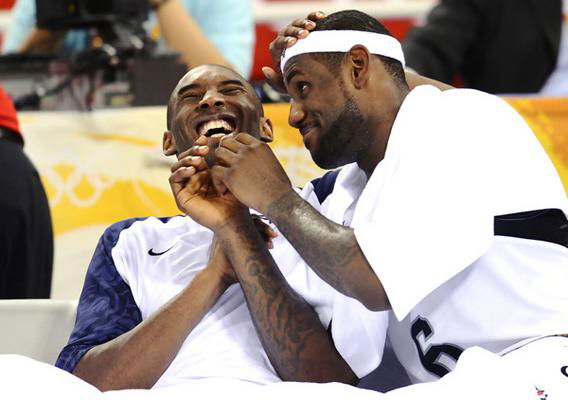 Kobe Bryant and Lebron James [USA]  have a laugh on the bench.