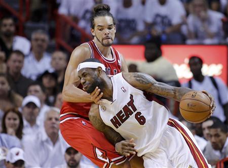 lebron james on the court wearing miami heat uniform dribbling the