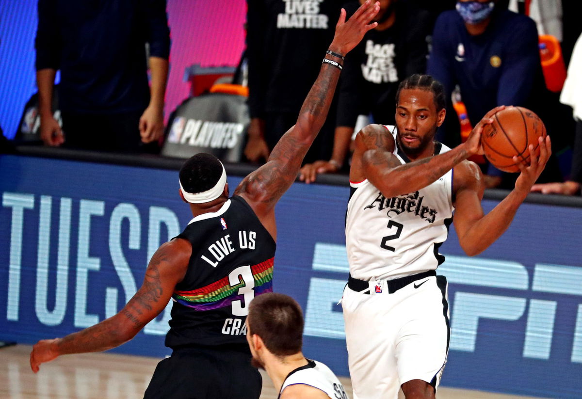 LA Clippers forward Kawhi Leonard passes the ball against Denver Nuggets forwards in game 6.