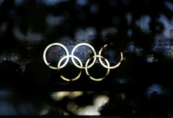 The giant Olympic rings are seen through a tree