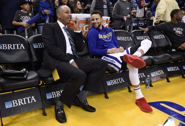 Dell Curry chats with his son Golden State Warriors&#8217; Stephen Curry (30) while sitting on the sideline before the start of their NBA game against the Charlotte Hornets at the Oracle Arena in Oakland, Calif. on Friday, Dec. 29, 2017. (Jose Carlos Fajardo/Ba