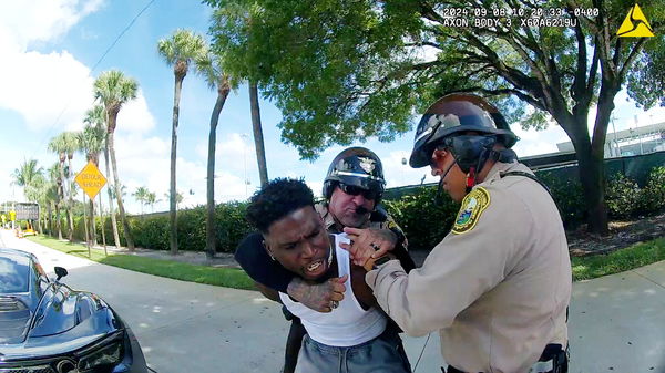 Miami Dolphins receiver Tyreek Hill is forced from his vehicle by Miami-Dade Police Department officers in Miami