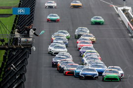 An official waves the green flag to start the first overtime period Sunday, July 27, 2025, during the Brickyard 400 at Indianapolis Motor Speedway