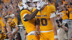 ASU Sun Devils quarterback Sam Leavitt (10) celebrates his touchdown run with teammate Jordyn Tyson (0)